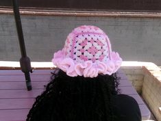 there is a woman wearing a pink crocheted hat on top of her head