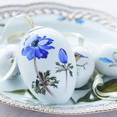 some white and blue decorated eggs on a plate with a ribbon around the edge,