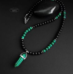 Necklace with 6 mm matt black onyx beads, green-black malachite beads and an embedded malachite pendant in the shape of an arrow. Mounted on sturdy coated stainless steel wire with a stainless steel carabiner clasp Pearl Necklace Men, Mens Beaded Necklaces, Neck Pieces Jewelry, Eyeglass Accessories, Men Bracelets, Malachite Pendant, Necklace Men, Neck Piece, Onyx Bead