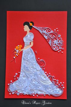 a woman in a white dress holding a bouquet of flowers on top of a red card