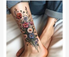 two women's feet with flowers on them and one is showing off her tattoo