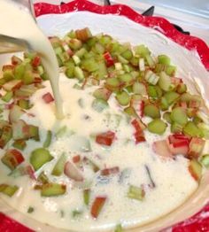 someone is pouring milk into a bowl filled with vegetables