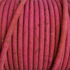 closeup of pink colored cord with holes in the middle and brown spots on it