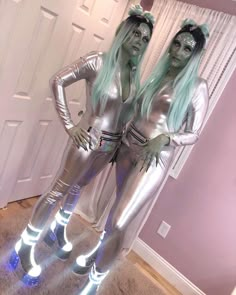 two women dressed in silver are standing next to each other