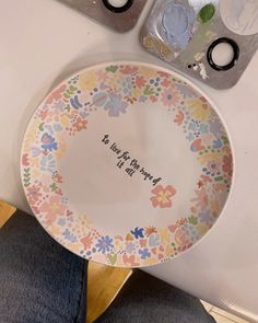 there is a plate that has been decorated with flowers and the words be happy on it