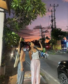 two women standing next to each other on a street