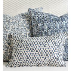 four blue and white pillows stacked on top of each other