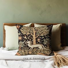 a decorative pillow on top of a bed next to a tasseled throw pillow