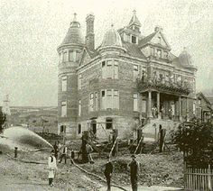 an old black and white photo of people in front of a large house