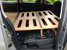 the back end of a van with an open cargo compartment and wooden flooring in it