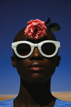 a woman with sunglasses and a flower on her head