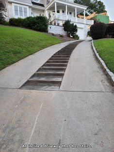 there is a set of stairs going up to the top of this hill in front of a large house