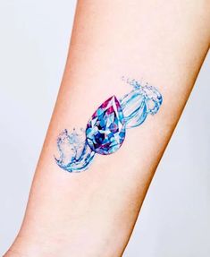 a woman's arm with water splashing on it and a diamond in the middle