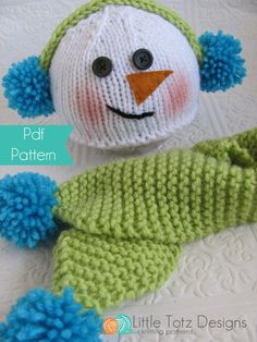 a knitted snowman with blue and green pom - poms