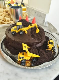 a birthday cake with construction trucks on top and dirt in the middle is featured for pinterest com