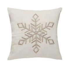 a white pillow with a snowflake embroidered on the front and side, in gold thread