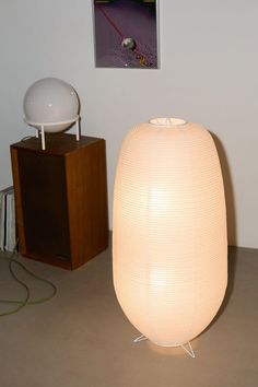 a large white lamp sitting on top of a table next to a wooden box with an object in it