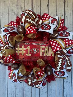 a football wreath with the number one fan on it and polka dot bows attached to it