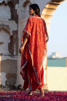 Ruby red cape with feather print and pearl, dori embroidered cutwork border. Paired with ruffle shirt and draped skirt.
Components: 3
Pattern: Printed, Embroidery
Type Of Work: Feather, pearl, dori
Neckline: Cape: Open, Shirt: Spread collar
Sleeve Type: Flared sleeves
Fabric: Flat Chiffon, Dola Silk, Organza
Color: Red
Other Details: 
Cutwork border
Lace embroidered panel
Occasion: Sangeet - Aza Fashions Elegant Red Designer Kaftan, Elegant Red Designer Wear Kaftan, Traditional Red Sets With Cape Sleeves, Red Designer Sets With Cape Sleeves, Red Designer Wear Set With Cape Sleeves, Festive Red Sets With Cape Sleeves, Red Traditional Drape Kaftan For Party, Designer Red Dabka Kaftan, Red Dabka Designer Kaftan