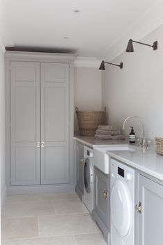 a laundry room with washer and dryer in the middle, cabinets on both sides