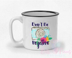 a white coffee mug with the words don't be negative in front of it