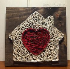 a string art house with a red heart