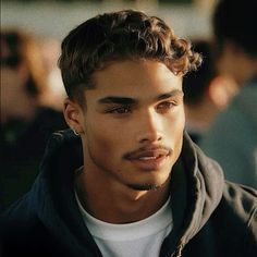 a close up of a person wearing a hoodie and looking at the camera with a serious look on his face