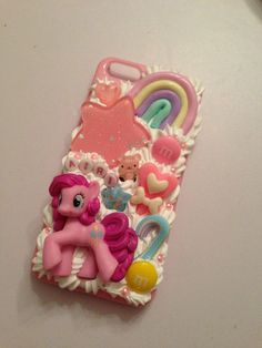 a pink pony phone case sitting on top of a white table next to other items