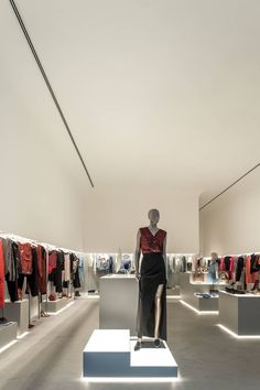 a woman's clothing store display with mannequins and clothes on racks