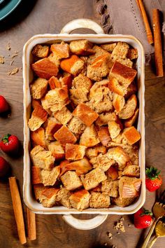 A rectangle baking dish is filled with vegan french toast casserole. The dish is on a wood table next to cinnamon sticks, gold forks, green plates, and fresh strawberries. Vegan French Toast Casserole, French Toast Casserole Recipe, Casserole Bake, French Toast Casserole Overnight, French Toast Casserole Recipes