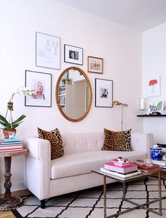 a living room filled with lots of furniture and pictures on the wall above it's coffee table