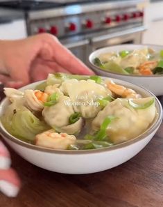 two bowls filled with dumplings on top of a wooden table