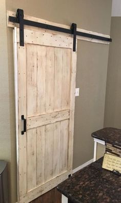 an old door is open in the corner of a room with granite counter tops and stools