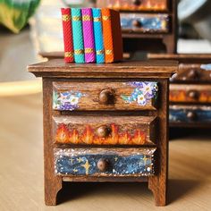 two wooden drawers with books on top of them sitting on a table next to each other