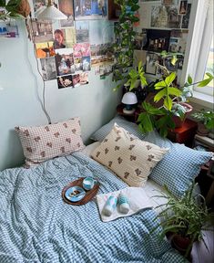 an unmade bed with pillows and pictures on the wall