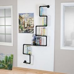 a wall mounted shelf with books on it in a living room next to a window