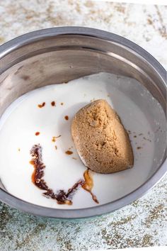 a rock in a bowl of milk on a counter top with the word love spelled out