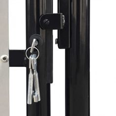 a pair of keys are attached to the door handle on a black gate with metal bars