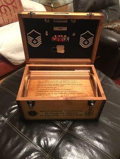 an open wooden box sitting on top of a leather couch