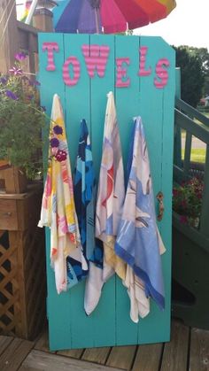 towels are hanging on a towel rack with umbrellas in the backgroung