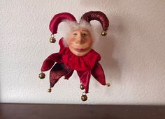 an old troll doll hanging on the wall with bells around it's neck and nose