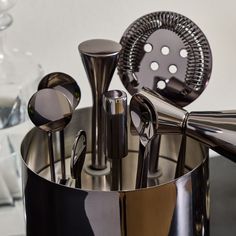 an assortment of kitchen utensils in a metal container