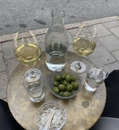 an assortment of wine glasses and olives on top of a table with a bottle