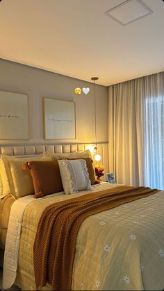 a bedroom with a bed, lamps and pictures on the wall