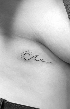 a woman's stomach with the sun and wave tattoo on it