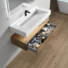 a bathroom sink sitting under a mirror on top of a wooden floor next to a counter