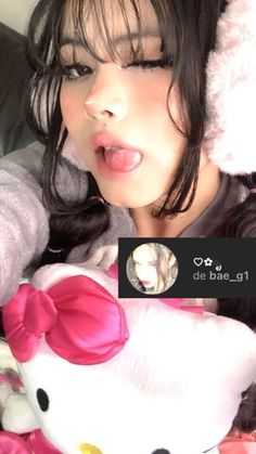 a woman sticking out her tongue with a hello kitty stuffed animal in front of her