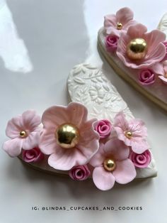 two pairs of shoes with pink flowers on the bottom and one pair has gold accents