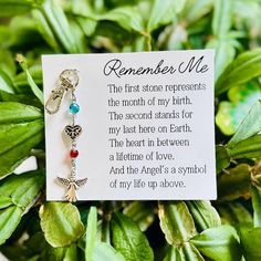 a memorial keychain hanging from a plant with a poem written on it that reads, remember me the first stone represents the month of my birth