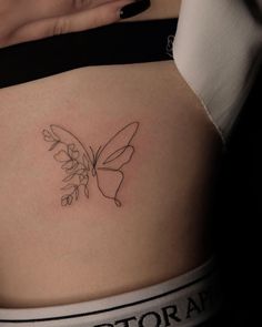 a woman's stomach with a butterfly tattoo on her belly and the word victoria written in cursive writing